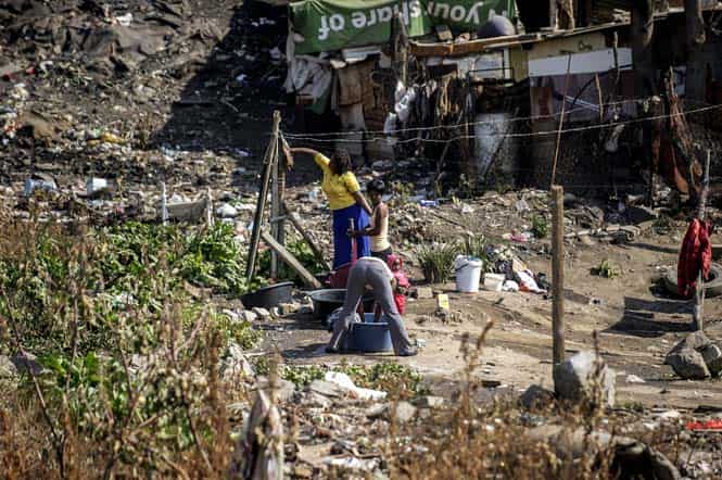 Women from Alexandra township wash their clothings using tap water the banks of a polluted river in Johannesburg, South Africa. (AFP photo)
</div) Women from Alexandra township wash their clothings using tap water the banks of a polluted river in Johannesburg, South Africa. (AFP photo)
</div)