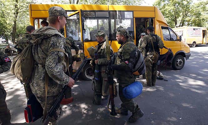 Armed pro-Russian separatists board a bus as they leave their positions in Kramatorsk in eastern Ukraine. (Reuters photo)</em) Armed pro-Russian separatists board a bus as they leave their positions in Kramatorsk in eastern Ukraine. (Reuters photo)</em)