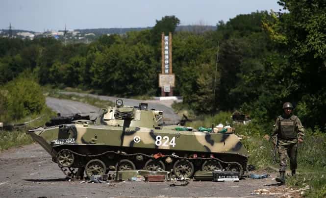 A Ukrainian soldier walks near a destroyed armoured vehicle at Slaviansk in eastern Ukraine. (Reuters photo)</em) A Ukrainian soldier walks near a destroyed armoured vehicle at Slaviansk in eastern Ukraine. (Reuters photo)</em)
