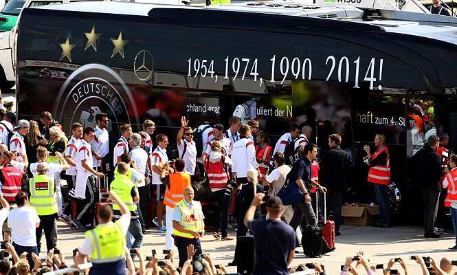 German national team players are greeted by fans as they board a bus at Berlin airport Tegel as they arrive from Brazil after winning the FIFA World Cup 2014. (AFP Photo)</em) German national team players are greeted by fans as they board a bus at Berlin airport Tegel as they arrive from Brazil after winning the FIFA World Cup 2014. (AFP Photo)</em)