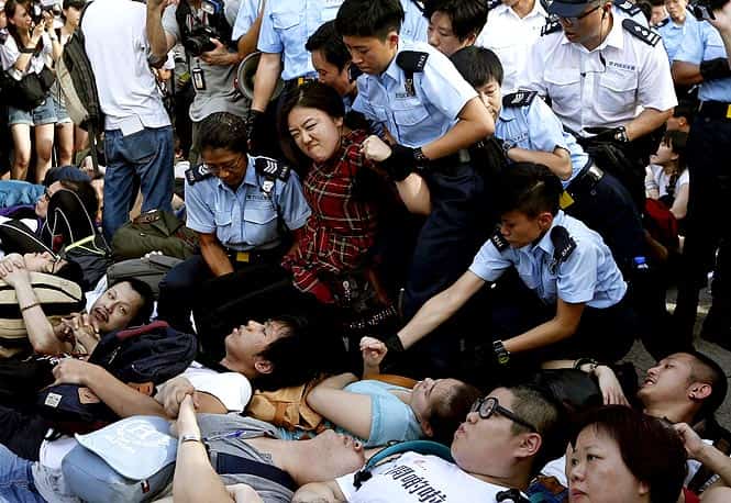 A protester reacts as she is dragged away by policewomen on a street outside HSBC headquarters at Hong Kong's financial Central district after staying an overnight sit-in with fellow demonstrators. (Reuters Photo)</em) A protester reacts as she is dragged away by policewomen on a street outside HSBC headquarters at Hong Kong's financial Central district after staying an overnight sit-in with fellow demonstrators. (Reuters Photo)</em)
