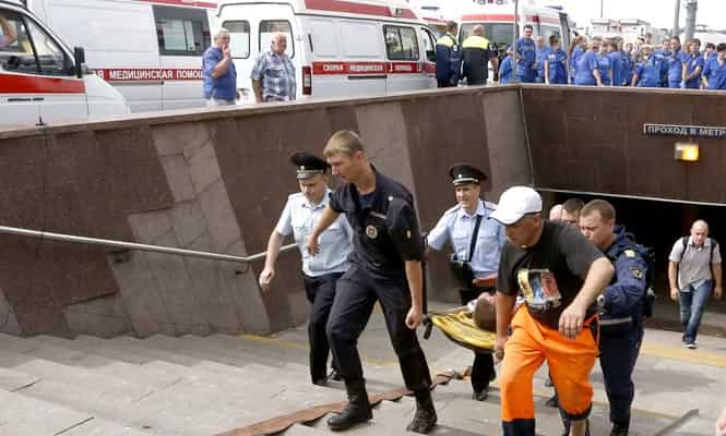 Members of the emergency services carry an injured passenger outside a metro station following an accident on the subway in Moscow. (Reuters photo) 
</div)