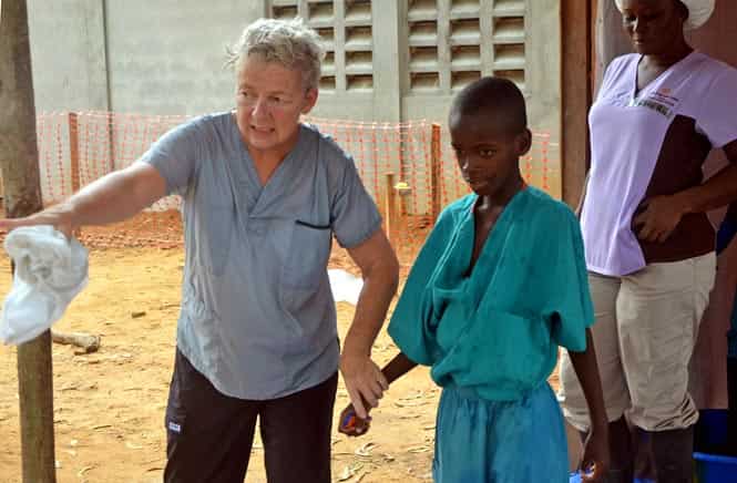 A 10-year-old boy walks with a doctor after being taken out of quarantine and receiving treatment following his mother's death caused by the Ebola virus, at the ELWA hospital in the Liberian capital Monrovia. (AFP Photo)
</div) A 10-year-old boy walks with a doctor after being taken out of quarantine and receiving treatment following his mother's death caused by the Ebola virus, at the ELWA hospital in the Liberian capital Monrovia. (AFP Photo)
</div)