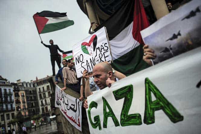 A teenager waves a Palestine flag as he shouts slogans against Israel beside a banner which reads, "No More Blood" during a protest against Israel's offensive in Gaza in Pamplona, northern Spain. (AP photo)
</div) A teenager waves a Palestine flag as he shouts slogans against Israel beside a banner which reads, "No More Blood" during a protest against Israel's offensive in Gaza in Pamplona, northern Spain. (AP photo)
</div)