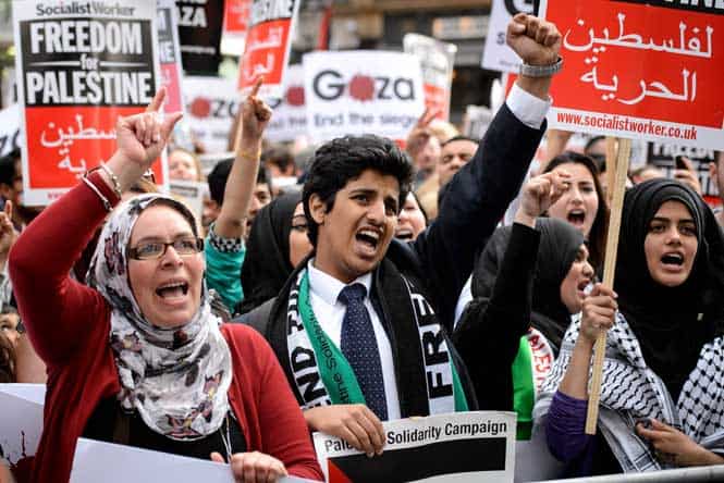 Demonstrators hold placards as they gather near the Israeli embassy in central London, calling for an end to violence in the Gaza Strip. (AFP photo)
</div) Demonstrators hold placards as they gather near the Israeli embassy in central London, calling for an end to violence in the Gaza Strip. (AFP photo)
</div)