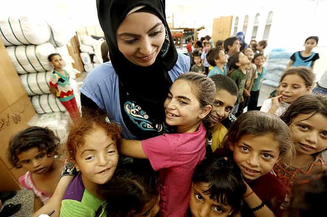 Palestinian children affected by the war gather around an UN volunteer during a group class as part of the United Nations community mental health programmes in the Gaza Strip. (AFP photo)
</div) Palestinian children affected by the war gather around an UN volunteer during a group class as part of the United Nations community mental health programmes in the Gaza Strip. (AFP photo)
</div)