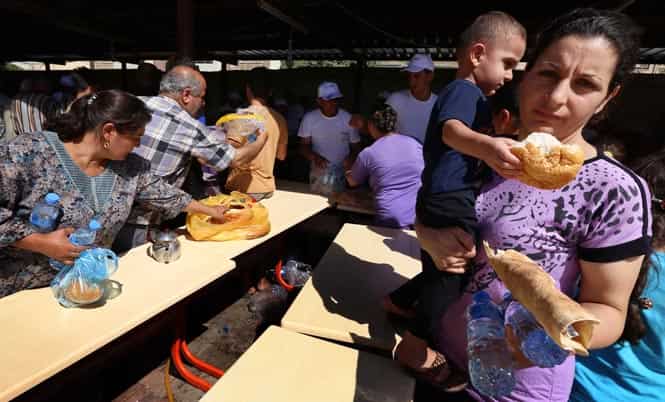 Iraqi Christians, who fled with their families the violence in Iraq's largest Christian town of Qaraqosh, receive food in the garden of Ainkawa's Saint Joseph church in northern Iraq. (AFP photo)
</div) Iraqi Christians, who fled with their families the violence in Iraq's largest Christian town of Qaraqosh, receive food in the garden of Ainkawa's Saint Joseph church in northern Iraq. (AFP photo)
</div)