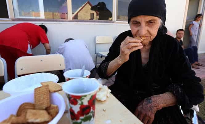 An Iraqi Christian, who fled the violence in Iraq's largest Christian town of Qaraqosh, eats in the garden of Ainkawa's Saint Joseph church on the outskirts of Arbil, northern Iraq. (AFP photo)
</div) An Iraqi Christian, who fled the violence in Iraq's largest Christian town of Qaraqosh, eats in the garden of Ainkawa's Saint Joseph church on the outskirts of Arbil, northern Iraq. (AFP photo)
</div)