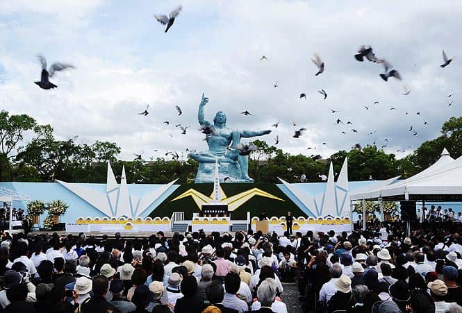 Pigeons fly around the peace statue during a memorial service for victims of the 1945 atomic bombing, at Nagasaki Peace Park. (AFP photo) 
</div)