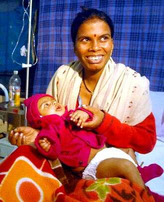 Three-month-old baby Rudra Zanjare with his mother Usha Zanjare were rescued by NDRF team from the landslide site in Malin village. (PTI Photo)</em)