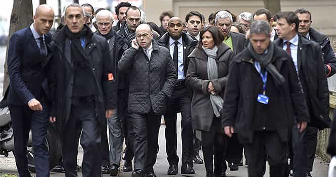 France's interior minister Bernard Cazeneuve (C, L) and Paris' Mayor Anne Hidalgo (C, R) arrive at the headquarters of the French satirical newspaper Charlie Hebdo in Paris on January 7, 2015. AFP Phot)