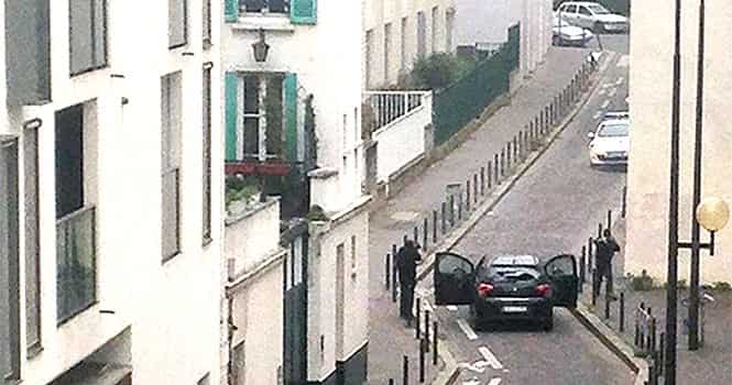 Armed gunmen face police officers near the offices of the French satirical newspaper Charlie Hebdo in Paris on January 7, 2015, during an attack on the offices of the newspaper. AFP Photo