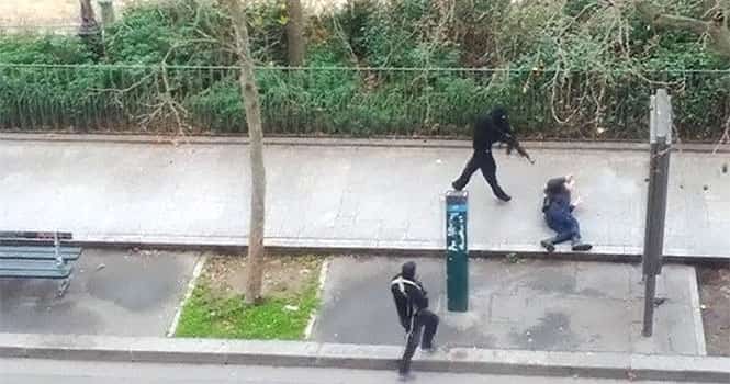 Gunmen shoot a wounded police officer (R) on the ground, outside the offices of French satirical newspaper Charlie Hebdo in Paris, in this still image taken from amateur video shot on January 7, 2015, and obtained by Reuters)