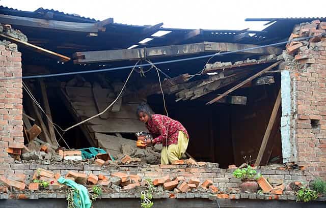 A Nepalese girl takes out belongings from her damaged house in Bhaktapur on the outskirts of Kathmandu on April 26, 2015. AFP Photo/Prakash Singh) A Nepalese girl takes out belongings from her damaged house in Bhaktapur on the outskirts of Kathmandu on April 26, 2015. AFP Photo/Prakash Singh)