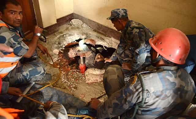 Nepalese rescue personnel help a trapped earthquake survivor (C/R) as his friend lies dead next to him in Swyambhu, in Kathmandu on April 26, 2015. (AFP Photo/Prakash Mathema) Nepalese rescue personnel help a trapped earthquake survivor (C/R) as his friend lies dead next to him in Swyambhu, in Kathmandu on April 26, 2015. (AFP Photo/Prakash Mathema)