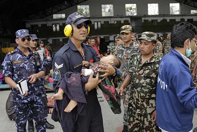 An Indian Air Force person carries a Nepalese child to a waiting ambulance at the airport in Kathmandu, Nepal on April 27, 2015. (AP Photo/Altaf Qadri) An Indian Air Force person carries a Nepalese child to a waiting ambulance at the airport in Kathmandu, Nepal on April 27, 2015. (AP Photo/Altaf Qadri)