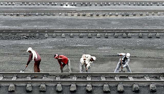 Men work inside a coal yard as they clear coal from a railway track on the outskirts of Ahmedabad. Reuters Photo Men work inside a coal yard as they clear coal from a railway track on the outskirts of Ahmedabad. Reuters Photo