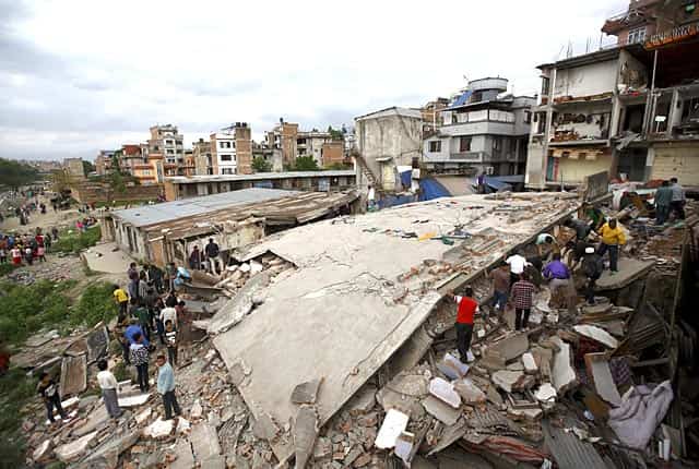 People gather near a collapsed house in Kathmandu, Nepal on April 25, 2015. Reuters Photo People gather near a collapsed house in Kathmandu, Nepal on April 25, 2015. Reuters Photo