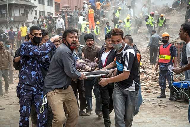 Emergency rescue workers carry a victim on a stretcher after Dharara tower collapsed on April 25, 2015 in Kathmandu. (Photo by Omar Havana/Getty Images) Emergency rescue workers carry a victim on a stretcher after Dharara tower collapsed on April 25, 2015 in Kathmandu. (Photo by Omar Havana/Getty Images)