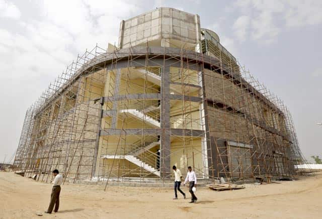 Engineers walk past a cooling system plant under construction inside Gujarat International Finance Tec-City (GIFT) at Gandhinagar in Gujarat. Reuters Phot)