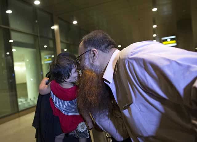 A man kisses his daughter, who was evacuated from Yemen, at the international airport in Mumbai. Reuters Photo A man kisses his daughter, who was evacuated from Yemen, at the international airport in Mumbai. Reuters Photo