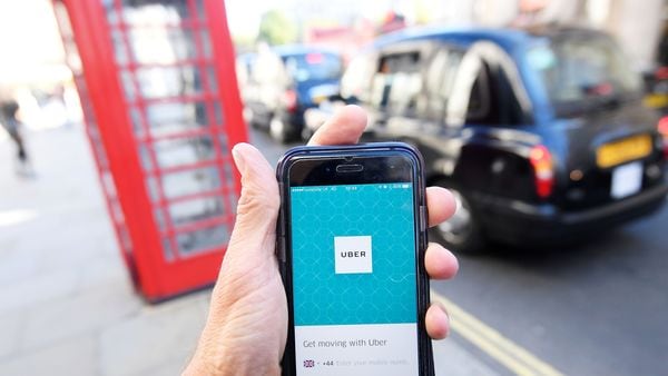 FILE PHOTO: A photo illustration shows a London taxi passing as the Uber app logo is displayed on a mobile telephone, as it is held up for a posed photograph in central London September 22, 2017. REUTERS/Toby Melville/File Photo (REUTERS)