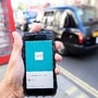 FILE PHOTO: A photo illustration shows a London taxi passing as the Uber app logo is displayed on a mobile telephone, as it is held up for a posed photograph in central London September 22, 2017. REUTERS/Toby Melville/File Photo (REUTERS)