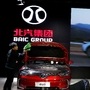 FILE PHOTO: Staff members clean a car at the stall of the BAIC Group automobile maker (Reuters)
