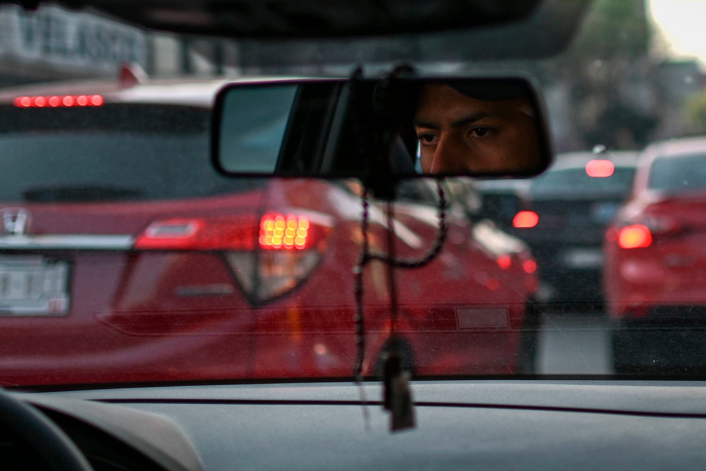 A man waits inside his car at a busy street in Mexico City.