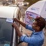 Navi Mumbai: A worker fixes a FASTag sticker on the windscreen of a car, at Vashi Toll Plaza on Sion Panvel Highway, Mumbai, Friday, Nov. 29, 2019. From Dec. 1, making toll payments via FASTag will become mandatory at national as well as state highways. (PTI Photo) (PTI)