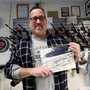 Andy Grossman, owner of RipTide Bait and Tackle and Brigantine Beach 4x4 Assist, holds a Beached Cars of Brigantine calendar featuring photos of cars stuck on the beach in Brigantine, New Jersey, U.S. December 16, 2019. Lori M. Nichols/Handout via REUTERS