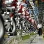 File Photo: A worker walks beside newly built motorbikes at the Bajaj Auto Ltd. plant in Pune, about 130 km (82 miles) from Mumbai August 9, 2007. REUTERS/Punit Paranjpe/Files