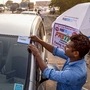 Navi Mumbai: A worker fixes a FASTag sticker on the windscreen of a car, at Vashi Toll Plaza on Sion Panvel Highway, Mumbai, Friday, Nov. 29, 2019. From Dec. 1, making toll payments via FASTag will become mandatory at national as well as state highways. (PTI Photo) (PTI)