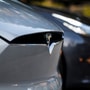 A Tesla badge is displayed on a Model X electric vehicle in San Ramon, California. Tesla Chief Executive Officer Elon Musk is pushing the Solar Roof and batteries as essential components of the company's drive to reduce fossil fuel use. Photographer: David Paul Morris/Bloomberg (Bloomberg)