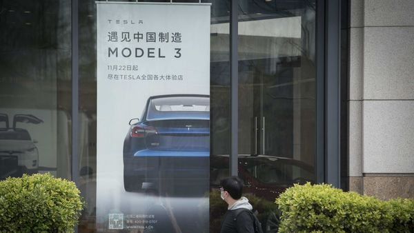 An advertisement for the Tesla Model 3 is displayed at a Tesla Inc. dealership in Shanghai. (Bloomberg)