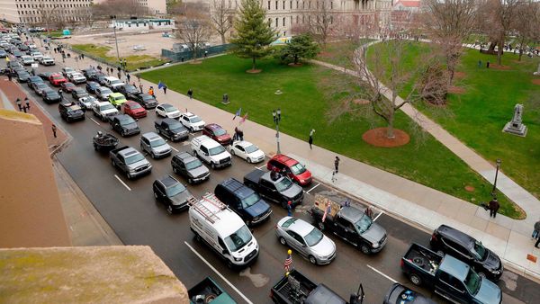People in their vehicles protest against excessive quarantine orders from Michigan Governor Gretchen Whitmer around the Michigan State Capitol in Lansing, Michigan on April 15, 2020. (AFP)