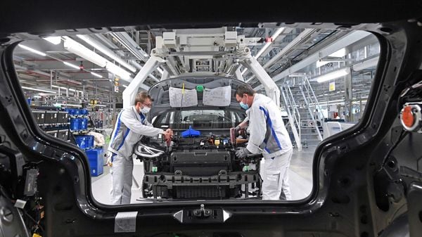 Employees of German car producer Volkswagen Sachsen, work with face masks in the assembly of the ID.3 in the vehicle plant in Zwickau, Germany. (AP)