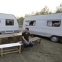A man sits on a bench in front of recreational vehicles (RVs) during a camping trip at a RV park on the outskirts of Beijing. (File photo) (REUTERS)