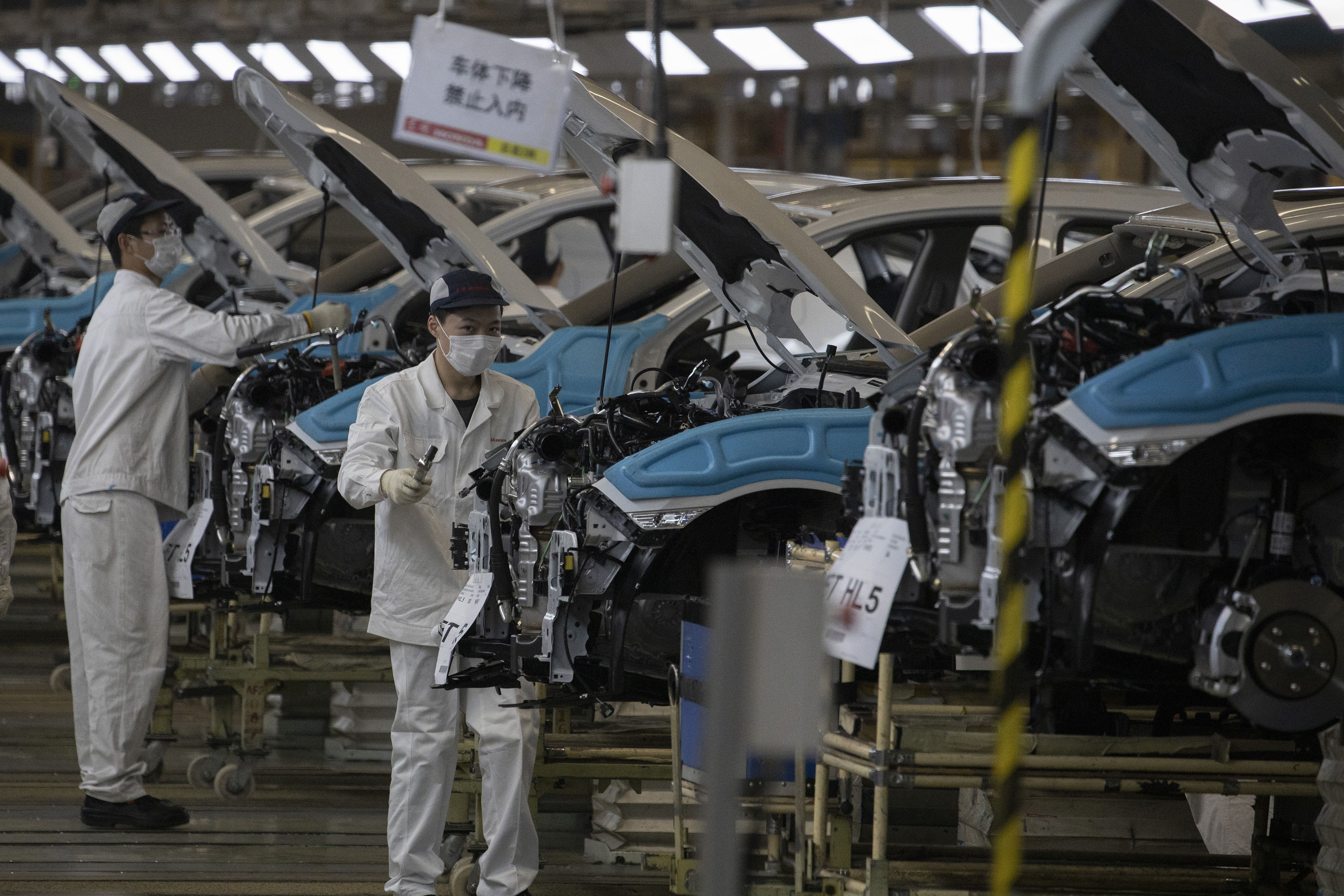 File photo - In this photo dated April 8, 2020, employees work on a car assembly line at the Dongfeng Honda Automobile Co., Ltd factory in Wuhan in central China's Hubei province.