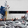 Workers in orange vests are seen outside Tesla's primary vehicle factory in Fremont, California. (REUTERS)