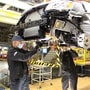 A weld curtain hangs between two operators working on the underbody of a Dodge Grand Caravan at and FCA plant to help maintain social distancing. (via REUTERS)