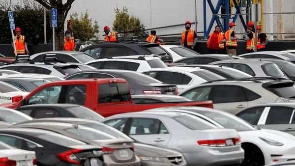 Workers in orange vests are seen outside Tesla's primary vehicle factory after CEO Elon Musk announced he was defying local officials' restrictions against the coronavirus disease (Covid-19) by reopening the plant in Fremont, California, U.S. (REUTERS)