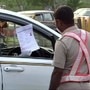A policeman checking pass of a commuter at Delhi-Gurugram border to control the movement of vehicles during coronavirus lockdown, in Gurugram.