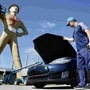 Andrew Nelson lifts the hood of his Tesla Model S in front of the Golden Driller. Tulsa's iconic Golden Driller statue is joining the effort to help lure automaker Tesla to build its new US assembly plant here. (AP)