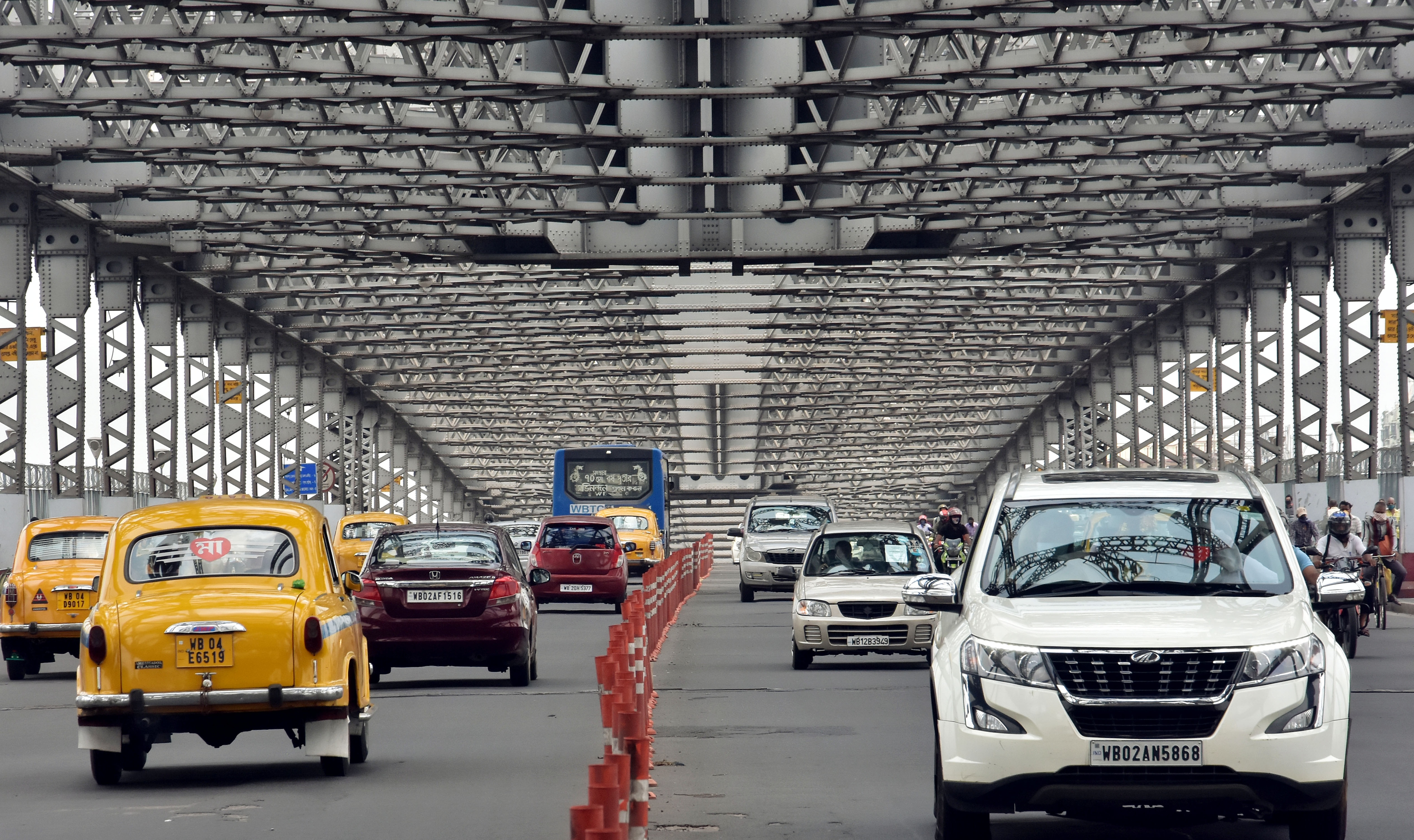 People using their private vehicles and cabs to reach their offices, markets, and other places due to unavailability of public transports, passing through the Howrah Bridge amid lockdown 4.0, in Kolkata.