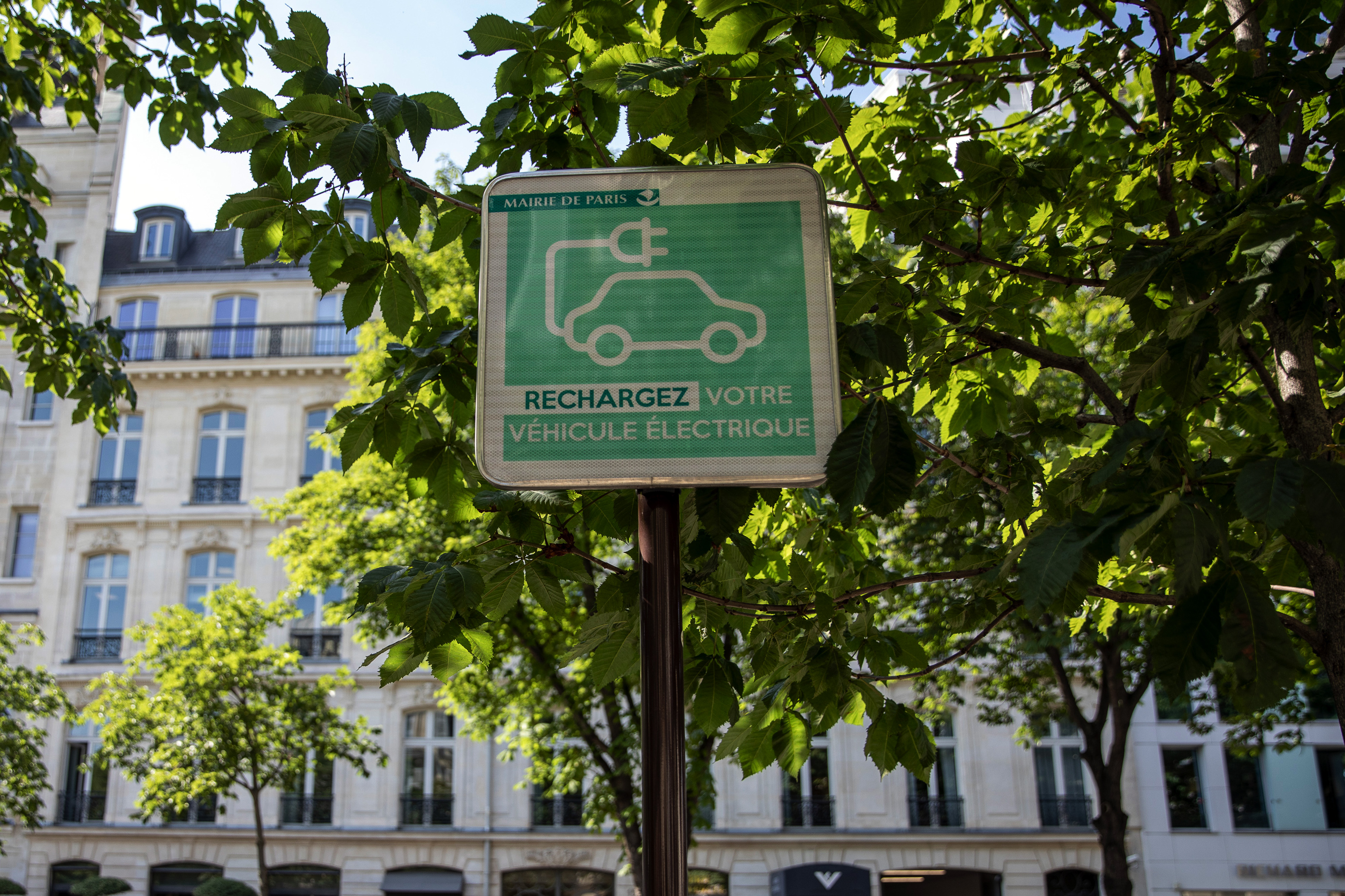 An electric vehicle charging station street sign sits on display in Paris, France.