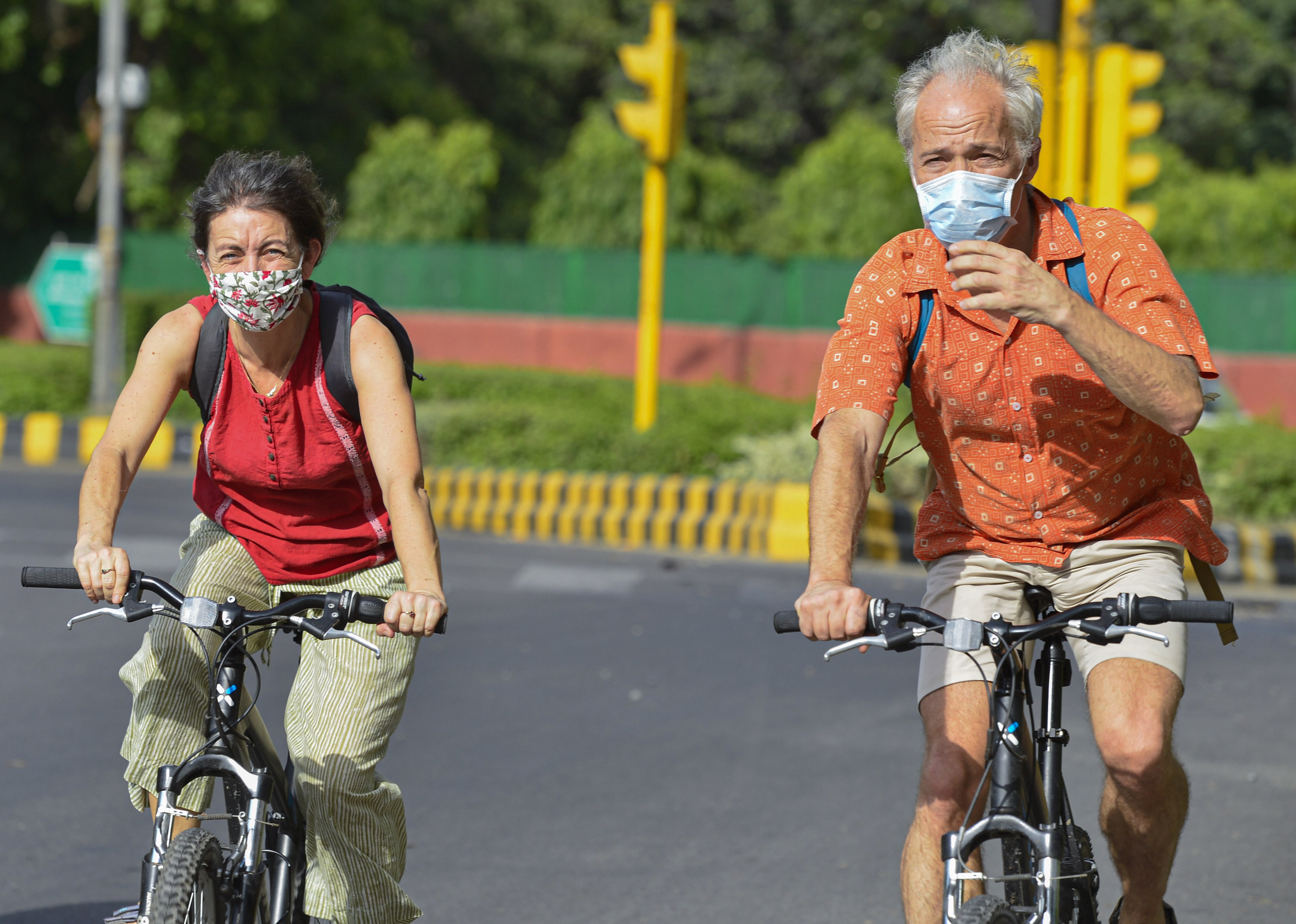 New Delhi: Foreigners, wearing masks, ride on bicycles during the ongoing nationwide Covid-19 lockdown, in New Delhi, Saturday, May 23, 2020