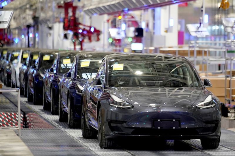 File photo of Tesla Model 3 EVs coming out of the company plant in Shanghai, China.