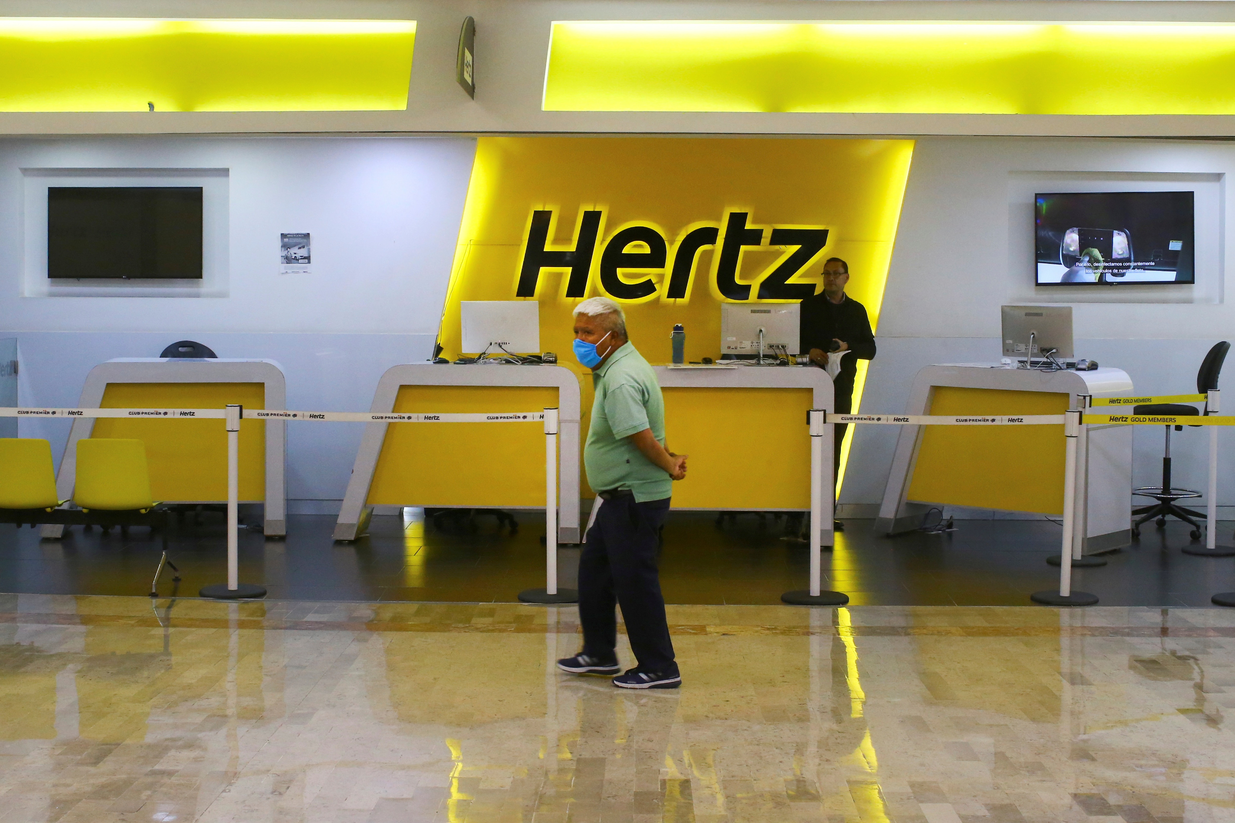 A passenger wearing a protective mask passes in front of a counter of the car rental company Hertz at the almost empty Benito Juarez international airport, as the spread of the coronavirus disease continues in Mexico City, Mexico, June 11, 2020. 