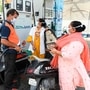 A gas station attendant (C) fills a motorbike tanks at a petrol station in Amritsar. (AFP)